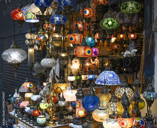 Сcollection of intricately patterned mosaic glass lanterns hangs in a market