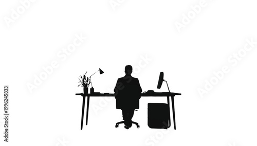 Businessman sits at a desk while working on a computer in a professional office environment setting.