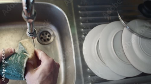 Washing the dishes by hand by the sink