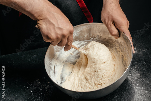 Φωτογραφία Mixing sticky dough in metal bowl with spoon baking process close up