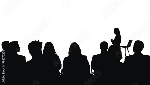 Audience members sit in a dark room watching a speaker present information during a business seminar.