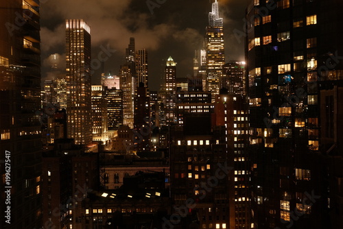 Obraz na płótnie New York City skyline at night, glowing skyscrapers under dramatic cloudy sky, urban cityscape, moody atmosphere, Manhattan nightlife
