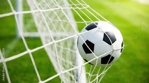 Soccer ball in goal net, action sport photography, successful goal celebration, stadium background, bright sunlight.