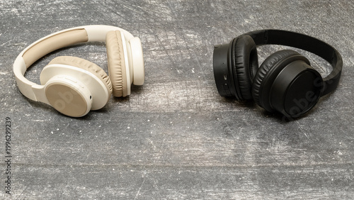 two pairs of full-size headphones of different colors on a gray surface