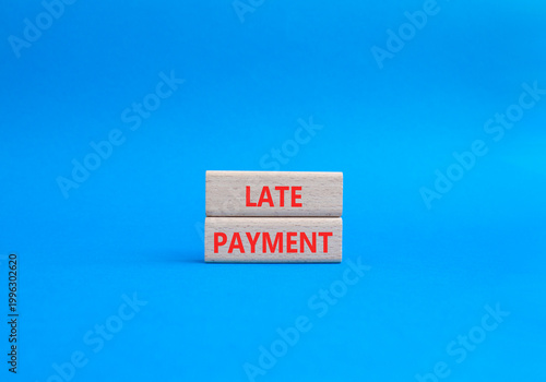 Late payment symbol. Concept word Late payment on wooden blocks. Beautiful blue background. Business and Late payment concept. Copy space