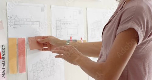 Woman placing pink swatch spotting match pinup layering strips finishing scheme, copy space