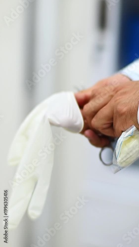 1080p video at 60 fps vertical of a doctor putting on his latex gloves for a medical examination
