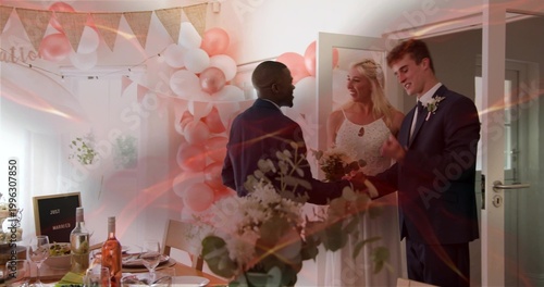 Greeting newlyweds wearing wedding attire at reception doorway, with bouquet, balloons and table