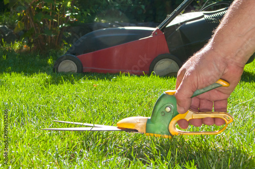 Professional lawn shears for trimming grass edges on a bright green lawn background