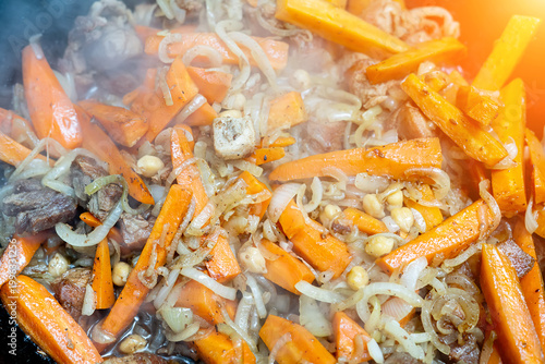 Fotografie Uzbek pilaf in the cauldron close up