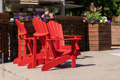 Red adirondack chairs on sunny outdoor patio. Muskoka chairs on city sidewalk in Ottawa.