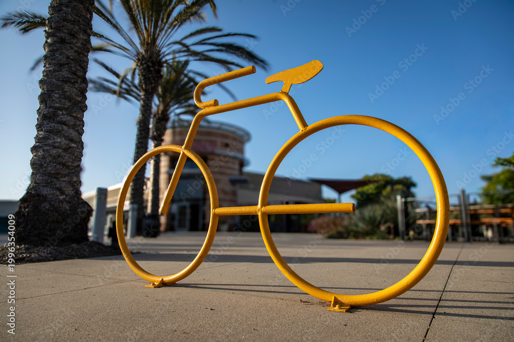 Fototapeta premium Low angle view of a yellow bicycle rack in the shape of a ten speed bike in a shopping area