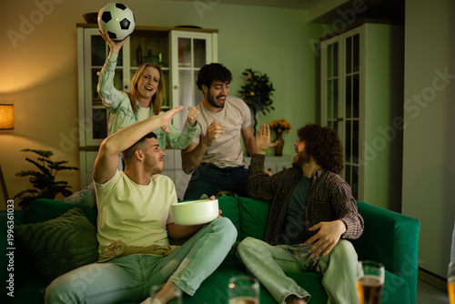 Photos Friends cheering watching football match together at home