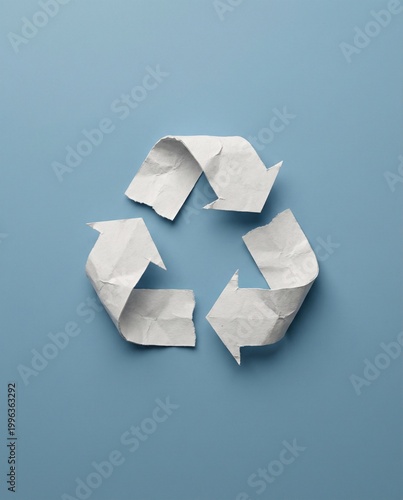 Recycle symbol made of crumpled white paper on blue background, eco-friendly environment sustainability concept, recycleconceptseries studio photography flat lay.