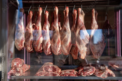 Принти на полотні Raw whole carcasses hanging on hooks in butcher market