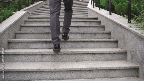 Modern businessman walking up the stairs in the city. Real time concept