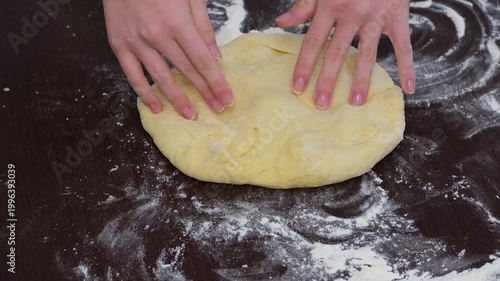 Woman hands stretching dough on floured wooden table pizza dough preparation closeup baking