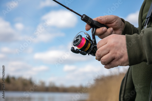 Extra Ultra Light (XUL) fishing. A XUL spinning rod with a XUL spinning reel in the hands of a fisherman on a spring day.