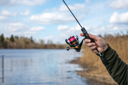 Extra Ultra Light (XUL) fishing. A XUL spinning rod with a XUL spinning reel in the hands of a fisherman on a spring day.