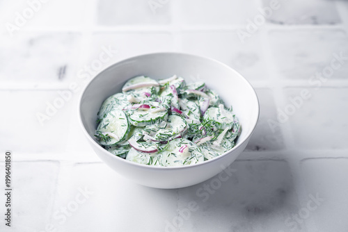 Cucumber red onion dill salad in a bowl on a white background