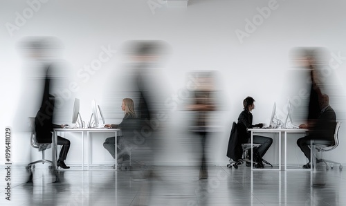 A blurred motion image depicts several individuals working at desks in a modern office setting, conveying a sense of activity and productivity.