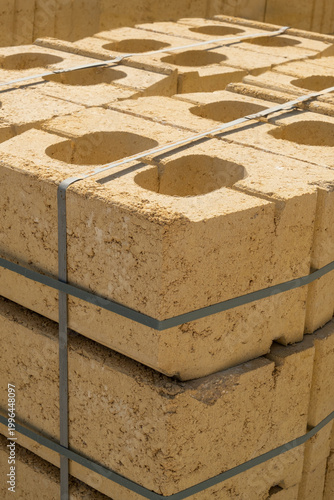 Stack of yellow limestone bricks secured with straps for construction building materials