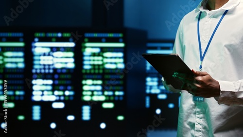 Canvas-taulu IT specialist walking through server rows performing data backups, close up