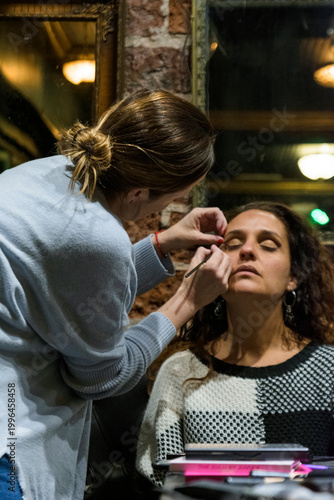 Make-up artist painting woman's eyes