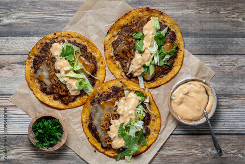 Freshly made smash burger tacos with burger sauce and parsley.
