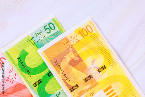 Foto Different new Israeli shekel NIS banknotes currency values on plain white background