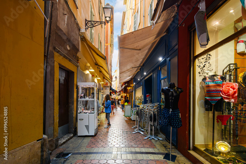 A narrow alley full of boutiques, shops and cafes in the historic Vieux Nice old town of Nice, France, on the Cote d'Azur French Riviera.