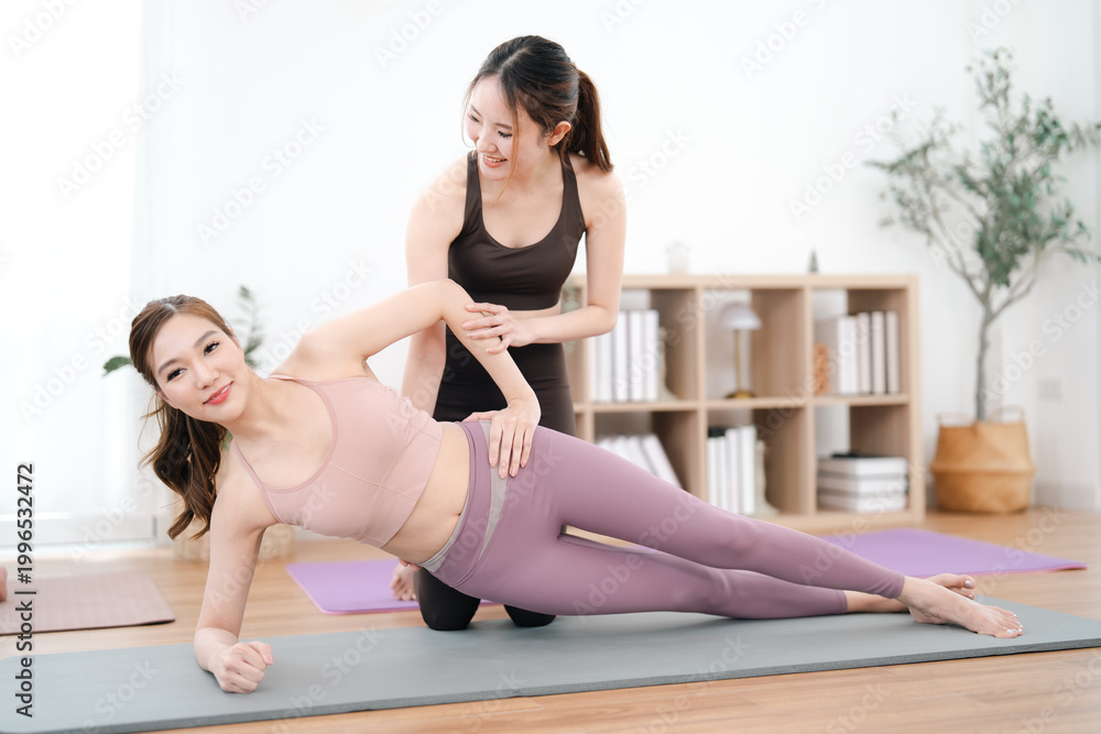 Obraz premium Side plank exercise with instructor in bright studio