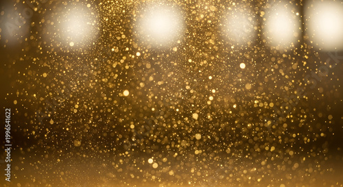 Golden glitter particles falling in dramatic lighting festive and abstract background