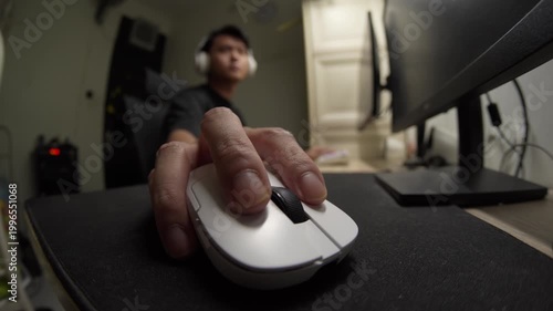 Close-up fisheye view of a moving a white gaming mouse rapidly back and forth in an Indonesian home office. Ideal for gaming, technology, and e-sports content