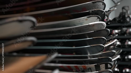 Rows of snowboards in ski resort rental shop equipment storage winter sports gear selection indoors shallow depth of field.