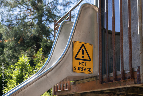 Tableau sur toile "Hot Surface" warning sign affixed to a stainless steel playground slide at a children's park in Australia
