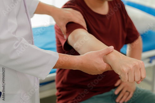 Fotografie Professional physiotherapist assisting a patient with arm muscle weakness through therapeutic hand exercises