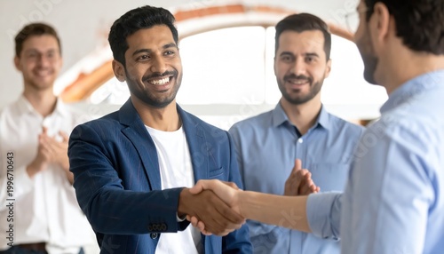 Successful business deal - Smiling men shaking hands in office.