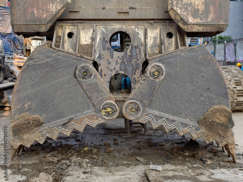 Close-up excavator grab bucket with mud