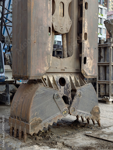 Heavy construction grab bucket on muddy site