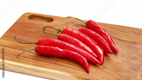 red hot chili pepper on wooden cutting board isolated on white	