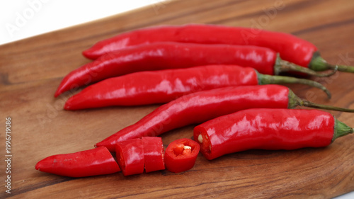 red hot chili pepper on wooden cutting board isolated on white	