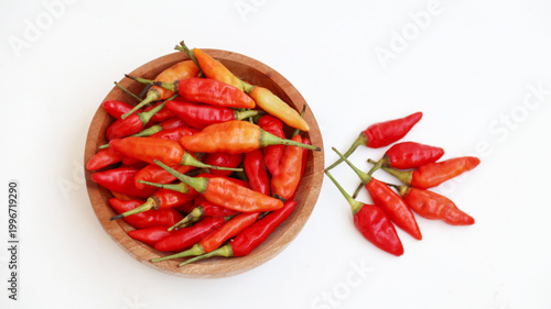 Red cayenne pepper (cabe rawit merah) on wooden bowl isolated on white background	