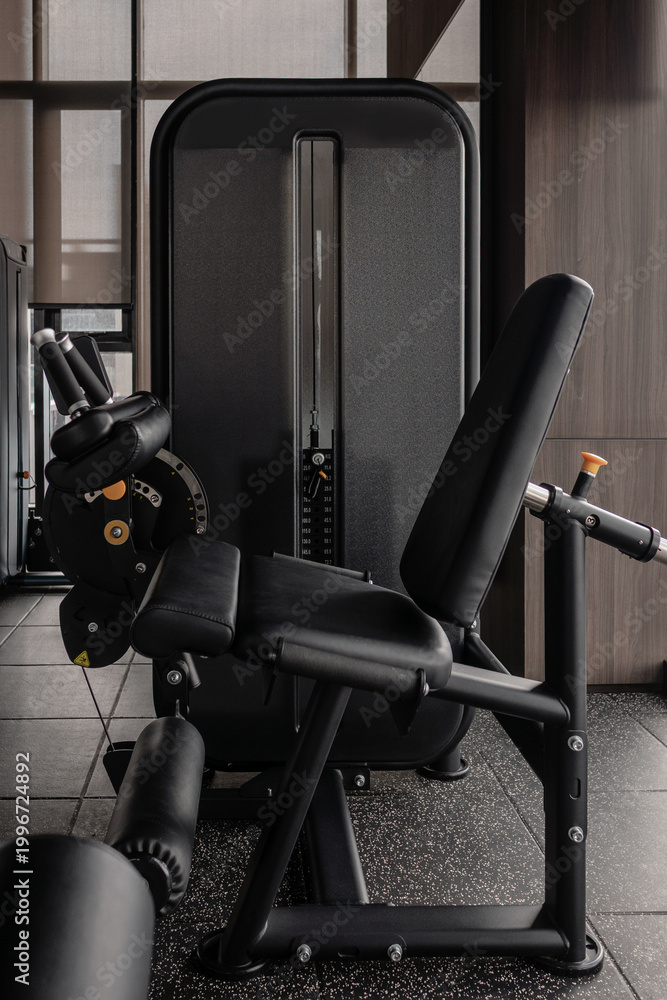 Obraz premium Leg extension machine in modern gym, strength training equipment close-up