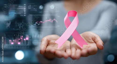 A hand gently holds a pink ribbon against a backdrop of data visualizations, symbolizing breast cancer awareness and research.