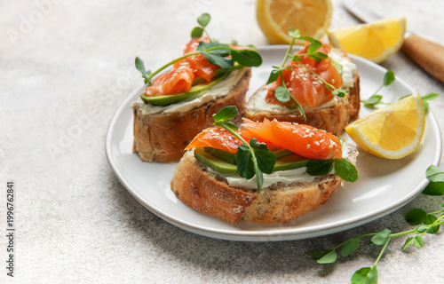 Smoked salmon bruschetta with avocado, cream cheese, and microgreens