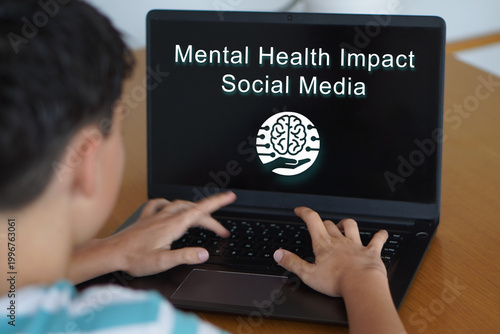 mental health impact social media. Teenager typing on his laptop