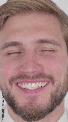 Face of Smiling Young Man on White Background, Vertical Video