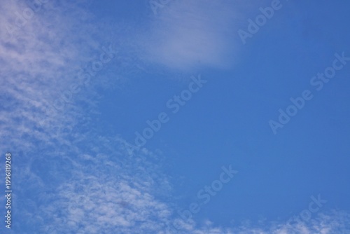Bild auf Leinwand Aesthetic blue sky background framed by soft patterned cirrocumulus clouds on the side