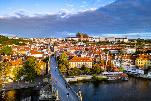 Foto Morning light casts a soft glow over Prague Castle and Charles Bridge